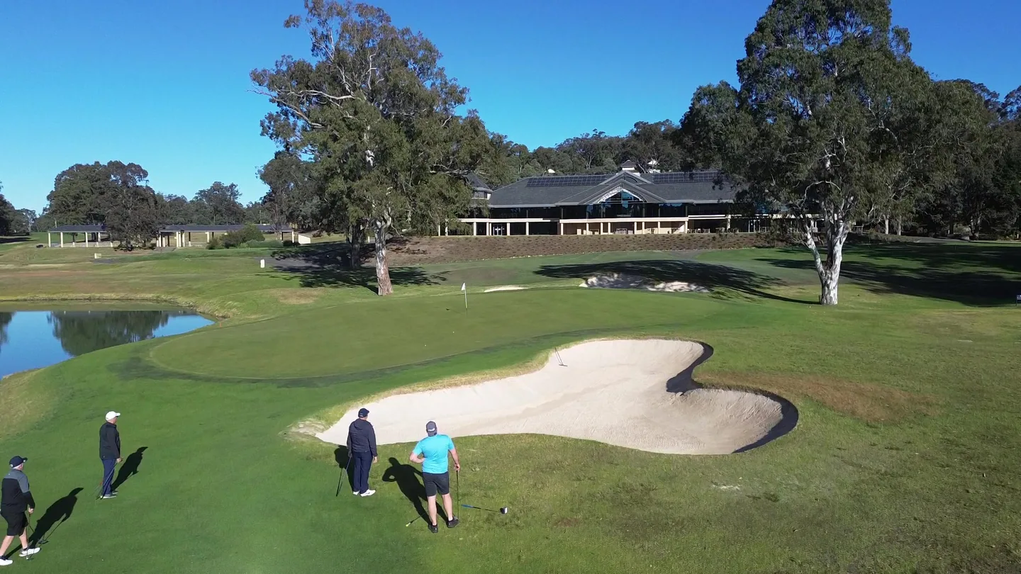 Golfers approaching a bunkered green at Riverside Oaks